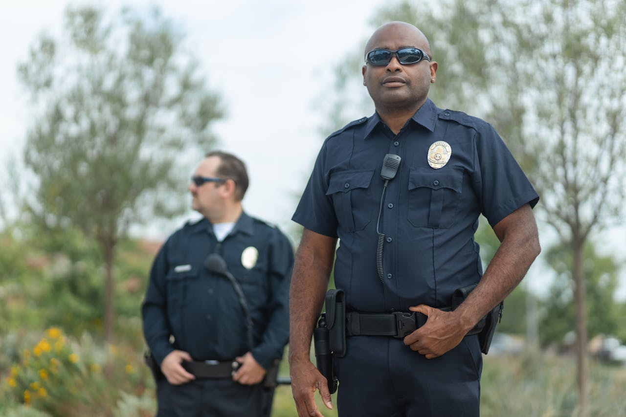 Two police officers in uniform ensure public safety, standing confidently outside.